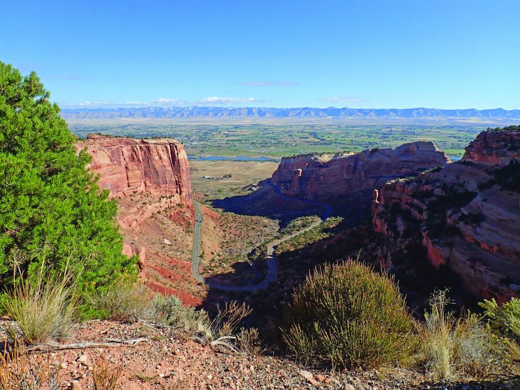 The red rocks of the National Monument with Fruita Colorado far in the distance.