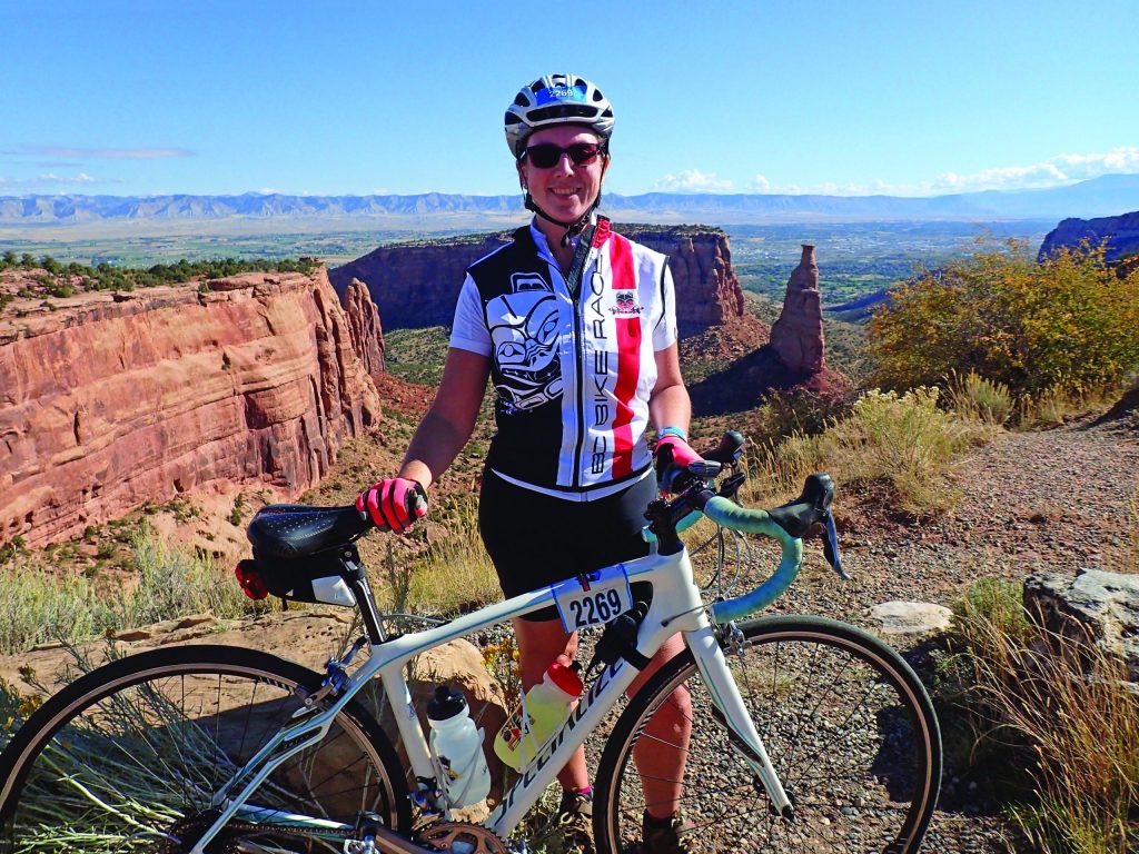 Me standing with my bike against the red rocks of the National Monument