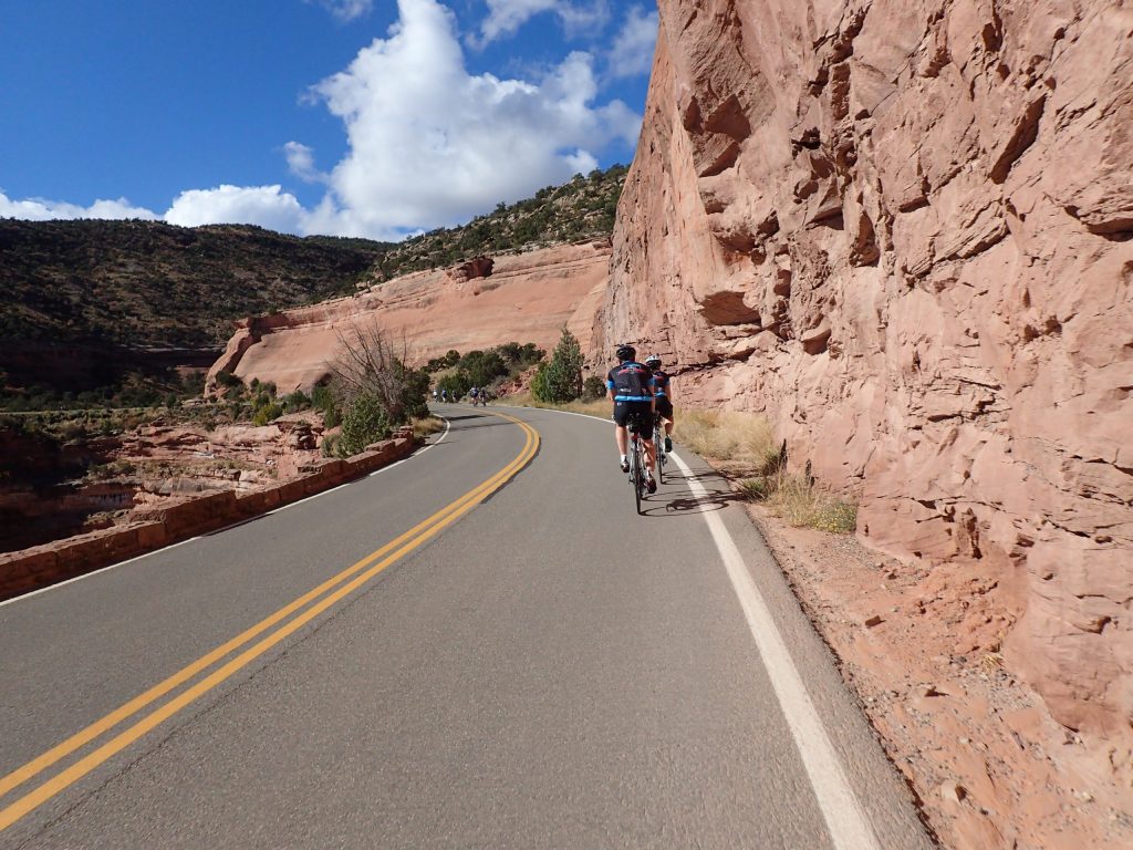Two cyclists agains the red rocks of the National Monument Grand Junction Colorado
